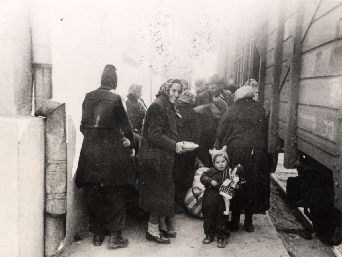 אישה וילדה עולות לרכבת הגירוש, מרס 1943