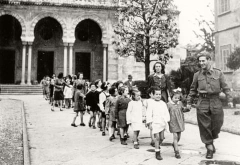 A Jewish Brigade soldier escorts children to school in Florence, Italy after the war.