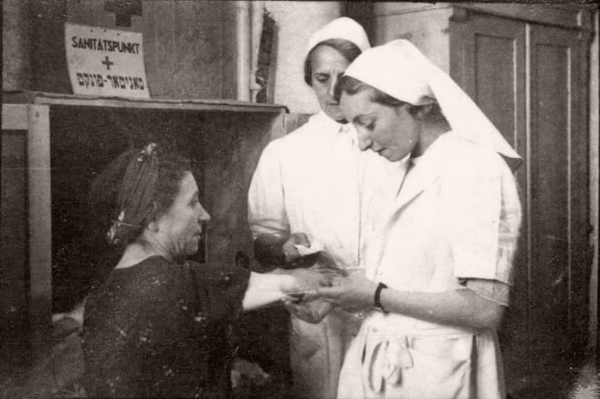 Nurses tending to a patient in a ghetto clinic, Lodz, Poland