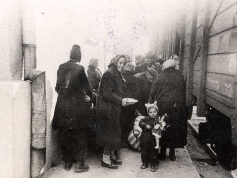 אישה וילדה עולות לרכבת הגירוש, מרס 1943