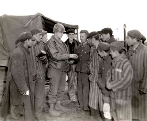 Private Hershel Wright of the US Army gives oranges to starving survivors of the Wöbbelin concentration camp May 5, 1945