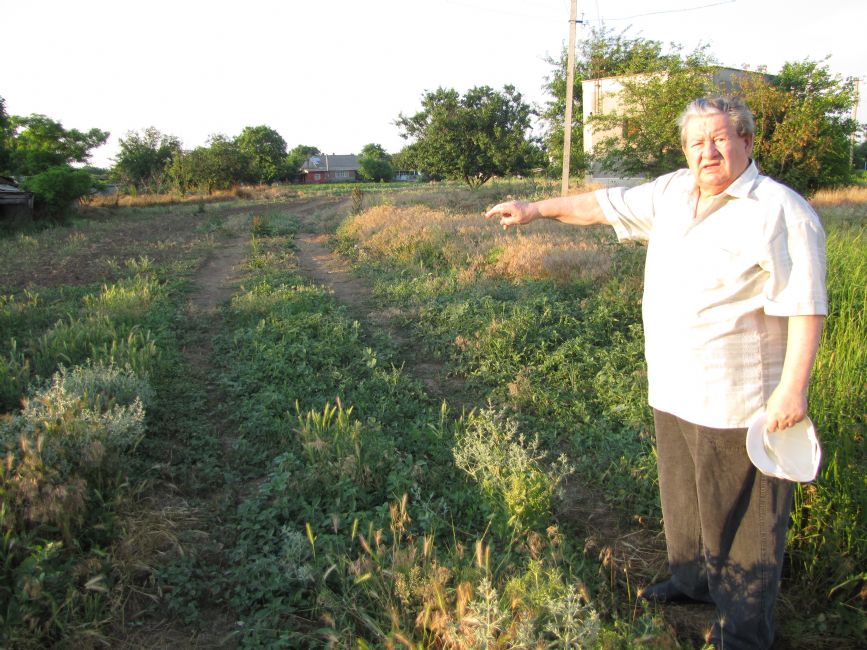 Leontil Kiskin showing the abandoned well in the center of Kalinine (former Kalinindorf) where the Jewish children from other places were shot to death. Photographer: 	Mikhail Tyaglyy, 2011.