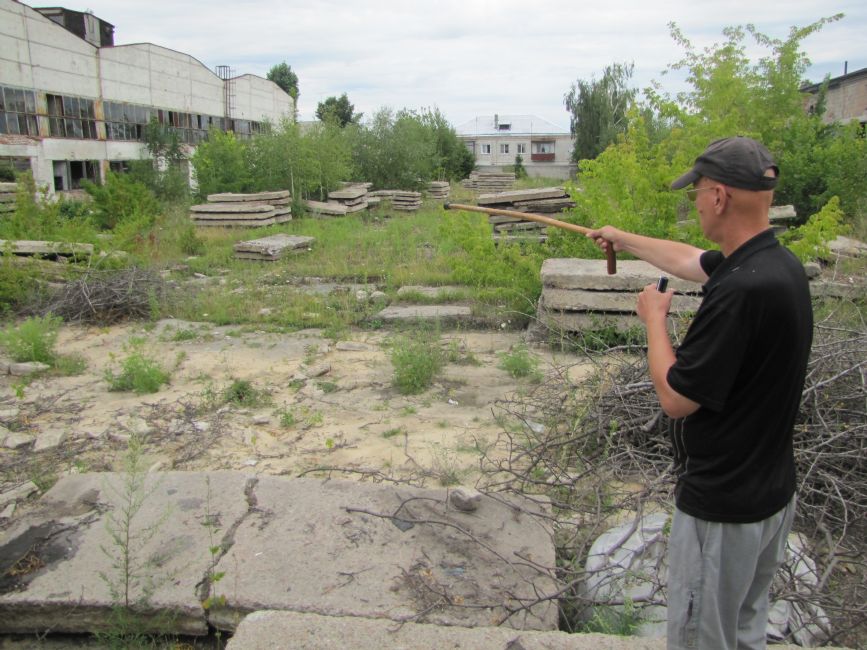 Alexander Provotorov showing the former murder site of the Machine Tractor Station. Photographer: 	Mikhail Tyaglyy, 2015.