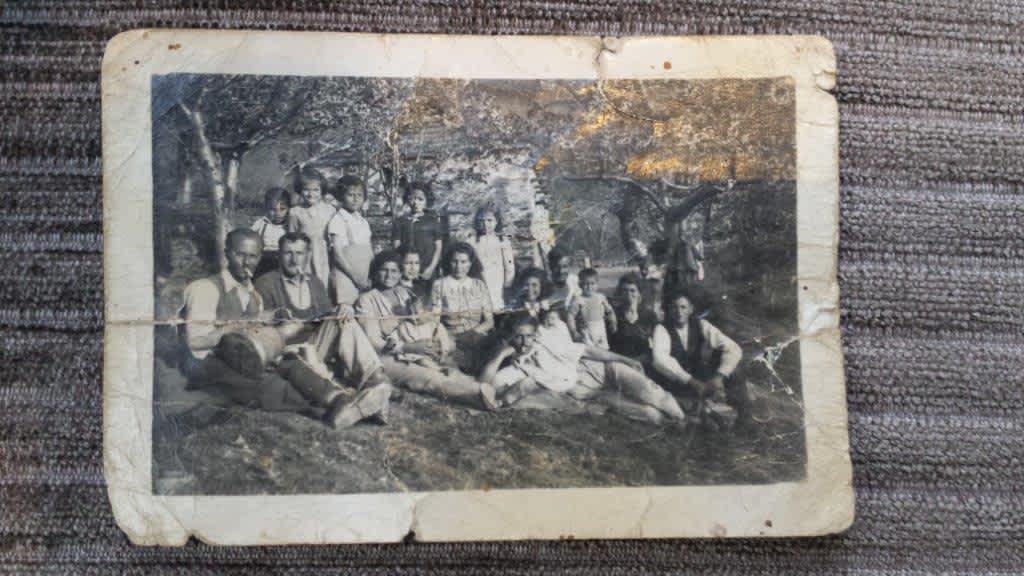 Israeli ambassador to Sweden, Isaac Bachman presenting the Righteous awards to Peder Rotvold at his home in the presence of the two survivors whom he and his parents rescued. 31 March 2016, Photo kept by the Voliotis family showing the exteded Hakim family during their hiding in the Pilion Mountains, First row left to right: Eliahu Hakim, (probably) Iakob Voliotis (brother of Apostolos), Hanna Hakim holding David, two unidentified persons, Leon Yehuda Hakim. second row: Ester and Rivka Yehoshafat, third row: Yuval Yehoshafat and son David, Rachel Bileli and husband Leon, Abraham Hakim, Lea Bileli, Ester Bileli, unidentified person, Yulia Luna Hakim.