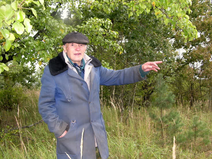 Karpichi native Ivan Kurchikov shows where the Collective Farm garden murder site was located. Photographer: 	Alexander Litin, 2008.