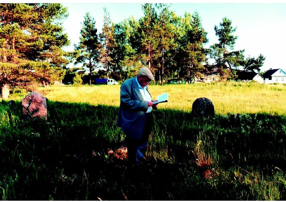 Valery Martsinkovskii reciting the Kaddish memorial prayer at the old Jewish cemetery of Velizh. Photographer: 	Inna Martsinkovskaya, 2011.